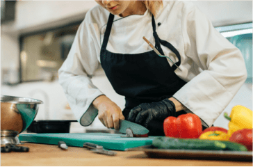 female-chef-chopping-vegetables-in-the-kitchen
