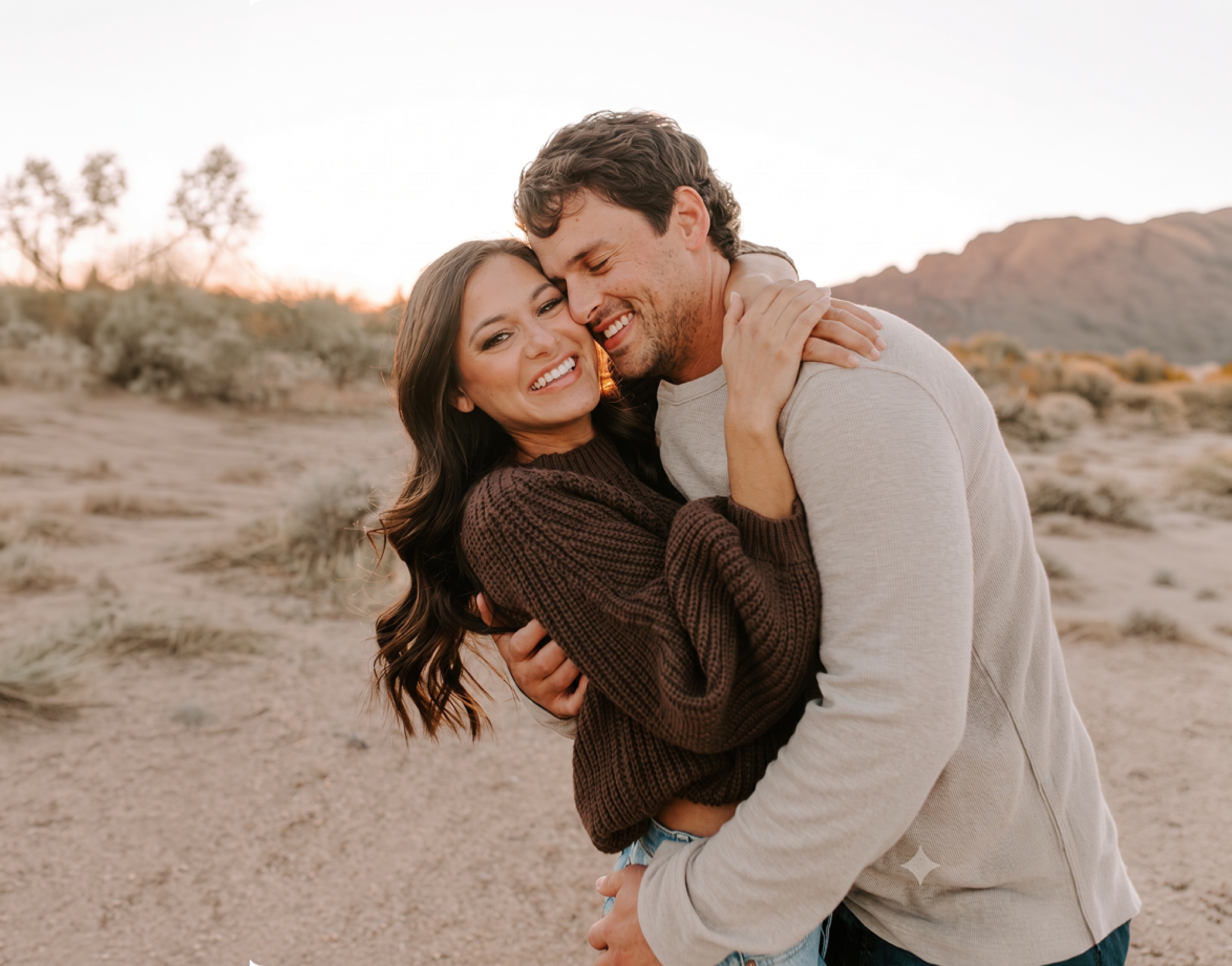 A smiling couple embracing outdoors